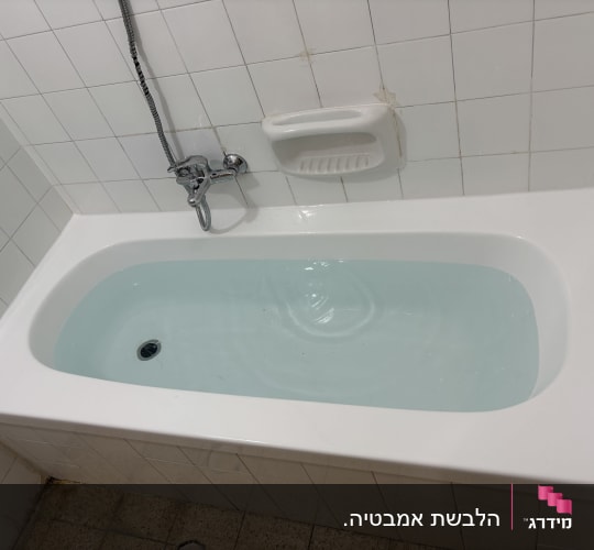 אמבטיה מלאה מים עם ברז ומחזיק סבון